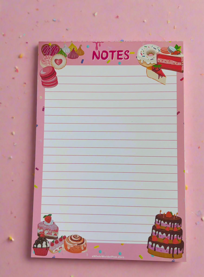 A5 Lined Note Pad Pink Patisserie Themed 50 Pages 120gsm, flat on white table with cakes, donuts, eclairs and sweets designed on pages